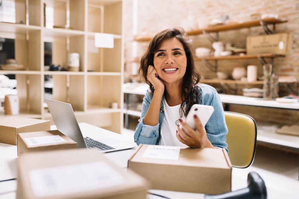 Cheerful,Online,Store,Owner,Looking,Away,Thoughtfully,While,Holding,A